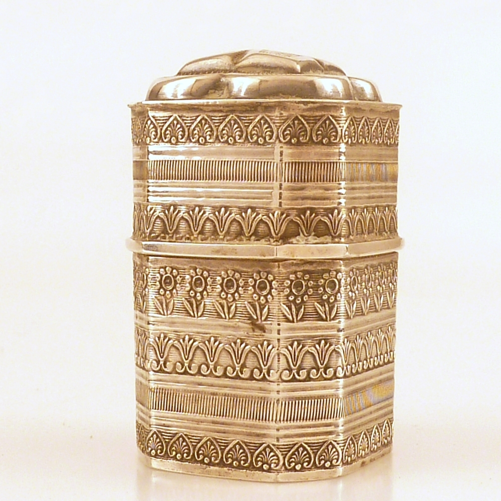 vierkante hoge busje met bloem en bladdecoraties en bovenop klaverblad