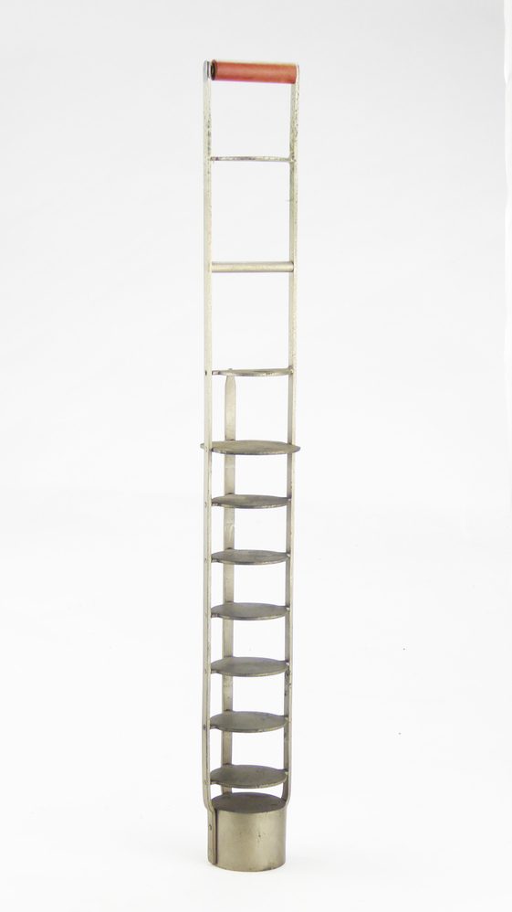 twee platte metalen staven die boven samenkomen met daartussen een houten klosje, onderaan een ronde dikke open voetstukje, met daarboven 7 ronde cirkelvormige plateau's en 1 halve cirkelvormige plateau, aan zijkant opstaande metalen plaatje met spitse punt