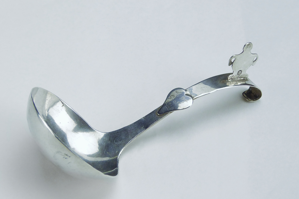 zilveren roomlepel, gebogen steel met ronde bak, op steel decoratief een soort vaas met jaarletter P = 1849, halverwege steel decoratief een hart met gegraveerde puntgravure A W G J 1849, gemerkt zilverkeurmerk leeuw en GH 17 = Geert Herwig Gzn, meestertekens 1839 - 1872 Veendam