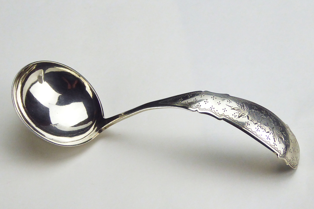 roomlepel. De steel heeft een mooie fijne stippelgravure met bloemdecoratie. Meesterteken: G 5 = Willem Hermannus Groenier (Veendam) meestertekens 1848 - 1890 Jaarletter: G = 1875 Minervahoofd Gehalte: 2e gehalte Lengte: 17 cm