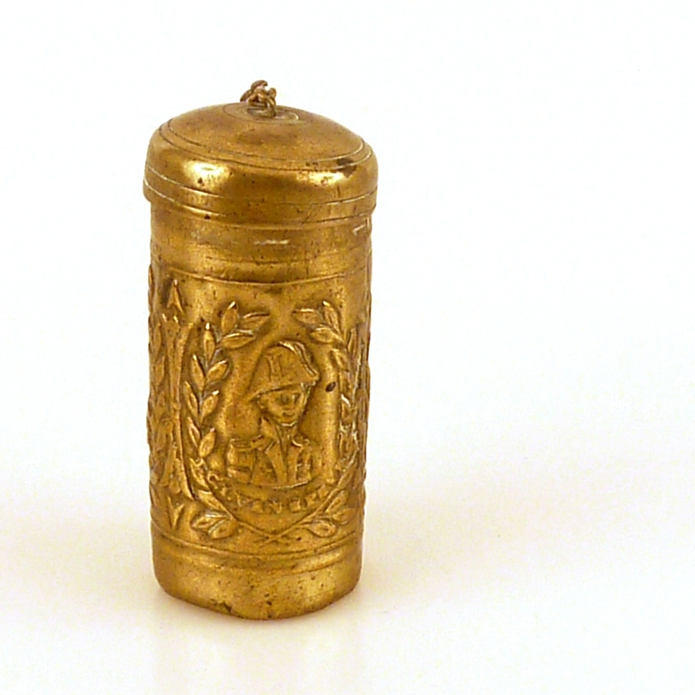 Tondeldoos met portretten van Nederlandse beroemdheden uit de Belgische Opstand, ca. 1840 langwerpige cilindervormig geelkoperen tondeldoosje, met deksel, zonder ketting, bedoeld om tondel en vuurslag in op te bergen, versierd met drie reliëfportretten die in drie lauwerkransen zijn aangebracht, te weten: Prins Willem II Frederik Karel van Oranje Nassau , opperbevelhebber Nederlandse leger en vloot, Generaal Baron Chassé , opperbevelhebber Nederlandse legereenheden Antwerpen en vlooteskader op de Schelde, en Luitenant ter Zee 2e klasse Van Speijk , commandant kannoneerboot No 2, met daaronder de resp. opschriften 'KR. PR. VAN ORANIE', 'B.D.H. CHASSE' en 'J.C.J. VAN SPEIJK', diameter 25 mm., hoogte 60 mm.