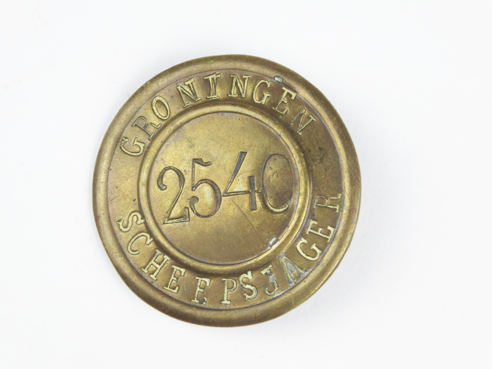 Ronde messing scheepsjagerspenning met op voorkant gegraveerde inscriptie Groningen Scheepsjager, en ingeslagen nummer 2540,  uitgereikt aan Aeito Huizinga, woonachtig in Winschoten, 48 jaar oud. Aeito Huizinga, geboren 9 apr 1877 te Midwolda, overleden 12 nov 1970 te Winschoten, beroep(en): dagloner, zoon van Daniel Huizinga en Vree Bolhuis. Gehuwd 26 okt 1901 te Bellingwolde met: Geertje Smit, geboren 2 mrt 1881 te Bellingwolde, overleden 15 dec 1934 te Winschoten, dochter van Aldert Smit en Albertje Hindriks. Afkomstig van vader van schenker.