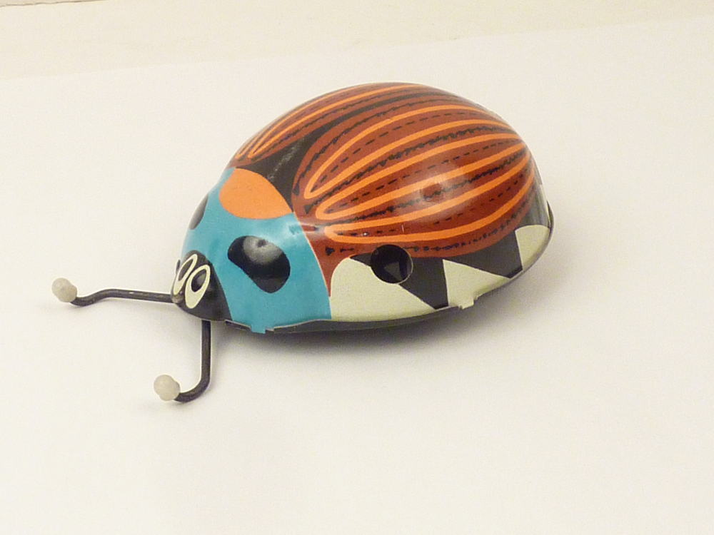 blikken kever met blauwe voorkant en oranje zwart gestreept schild, wielen aan onderkant