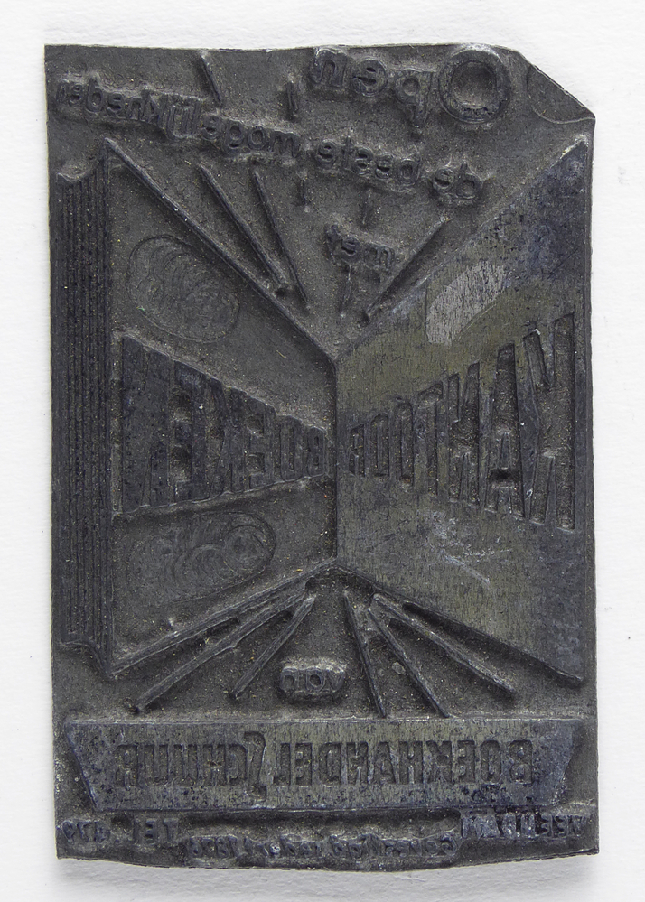 rechthoekige non ferro metalen cliche met afbeelding openstaande boek met hierin inscriptie de beste mogelijkheden met kantoor boeken van boekhandel Schuur Veendam gevestigd 58 ber? 1876 tel 476, op achterkant oranje sticker met zwarte belettering boek- en kantoorboekhandel Schuur Veendam, afkomstig van kantoorinstallaties Bv Schuur te Veendam
