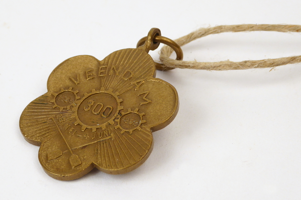 bronzen bloemvormige penning met afbeelding graversark ( een bepaalde soort schep gebruikt bij de vervening) en tandwiel met inscriptie Veendam 1655 1955 28 mei - 4 juni 300