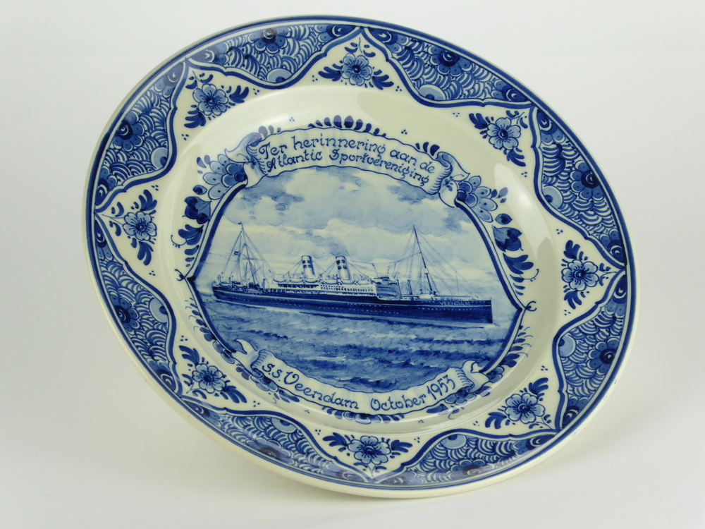 ronde aardewerken bord met op de rand bloemmotieven, in het midden afbeelding van een stoomschip met opdruk boven in banier : Ter herinnering aan de Atlantic Sportvereniging, beneden inscriptie in banier S.S.Veendam October 1953, aan achterkant gemerkt gekroonde ZG = merk van plateel en pijpenfabriek Zenith fa P.J.v.d. Want Az, 83 j.v. Delfts Bl Made in Holland aangeboden aan Kapitein H. Oldenburger beschermheer