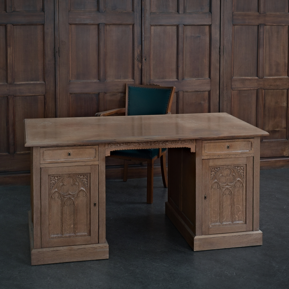 eikenhouten bureau bestaande uit blad met aan weerszijde een kast, hierin een lade, aan achterkant zit ook een kast, deuren en zijkanten rijkelijk bewerkt, hoort bij een Christushoofd dat is geschonken door de Veendamse Parochie aan Bernard Oosterman ter gelegenheid van zijn priesterwijding in 1956 te Groningen.