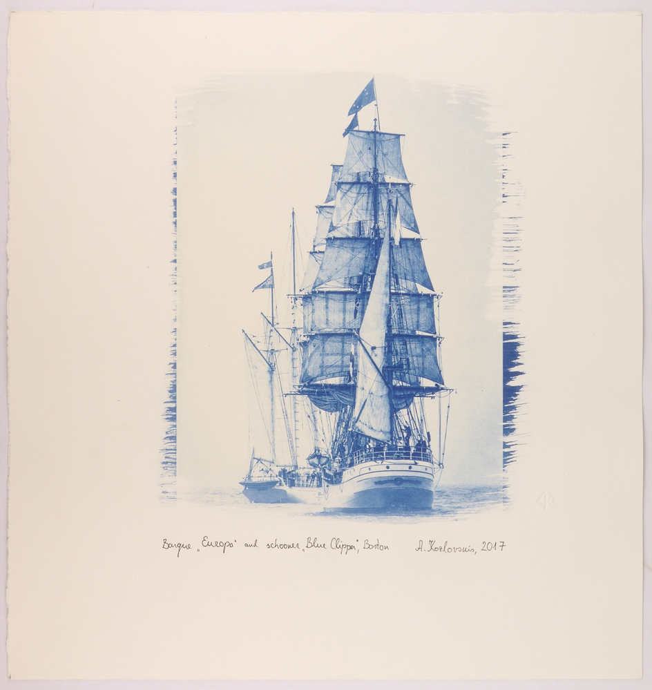 cyanotype foto afgedrukt op aquarelpapier geheel in het blauw met een afbeelding van twee achter elkaar liggende zeilschepen gefotograveerd bij Bermuda, onder afdruk met zwarte pen geschreven : Barque "Europa" (nederlands schip) and schooner "Blue clipper", Boston, rechts gesigneerd Andris Koslovskis 2017, daarnaast watermerk in papier AK