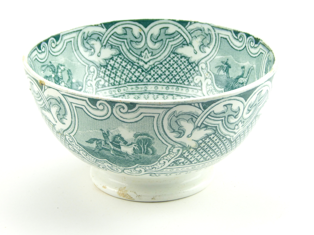 aardewerken kom op standvoet van het merk Petrus Regout & Co, Maastricht, decornaam Lasso, diameter 14,9 cm, op binnenkant 4 x groene decoratie van man op paard met lasso die paarden vangt, buitenkant groene decoratie van loslopende paarden en man op paard met lasso, chip uit onderkant bodem, gemerkt met beeldmerk 71 A van Petrus Regout, opgedoken door British Sub Aqua Club, Branch 501, ook wel de 501 Divers uit Folkstone, uit het wrak van de op 19 november 1887 na een aanvaring met het stoomschip Rosa Mary gezonken stoomschip W.A. Scholten, via hun woordvoerder Glyn Jones geschonken aan het Veenkoloniaal Museum.