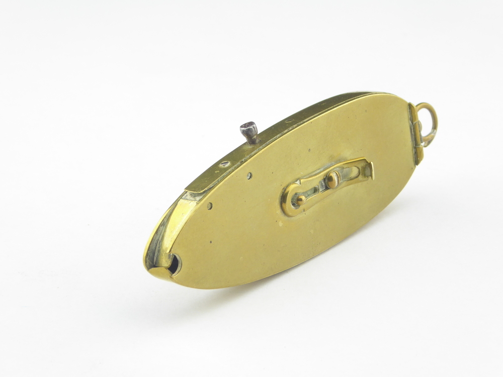 ovalen messing voorwerp, met aan uiteinde een gat en keerzijde een ring, aan zijkant een pen die in te drukken is, dan beweegt er een koperen staaf aan de binnenkant, het gat gaat dan open en laat op die manier een beetje kruit wat in het binnenste zit vallen, zijkant is verwijder baar met een scharnier en er zit een soort slot op gemonteerd, zodat het gat dicht blijf. Kruithoorn / flesje voor een damespistool, afkomstig uit de familie Hoving of Topper.