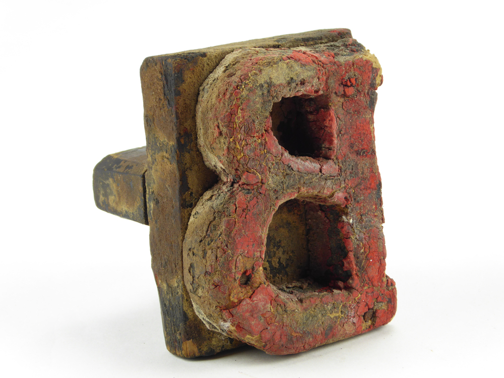 houten rechthoekige letterstempel ,met in matrijs in spiegelvorm gesneden de letter B oorspronkelijk rood van kleur