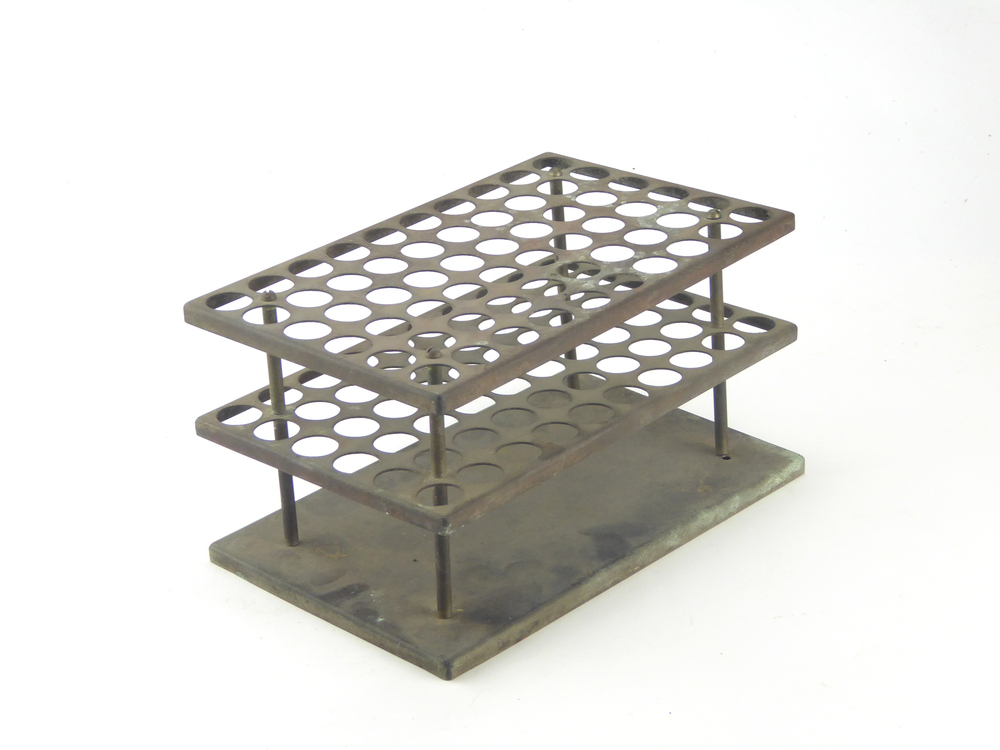 rechthoekige verkoperde non ferro metalen constructie van een onderplaat met daarboven vastgehouden door staven met bovenin een schroef, 2 evenwijdige plateaus met elk 50 gaten.