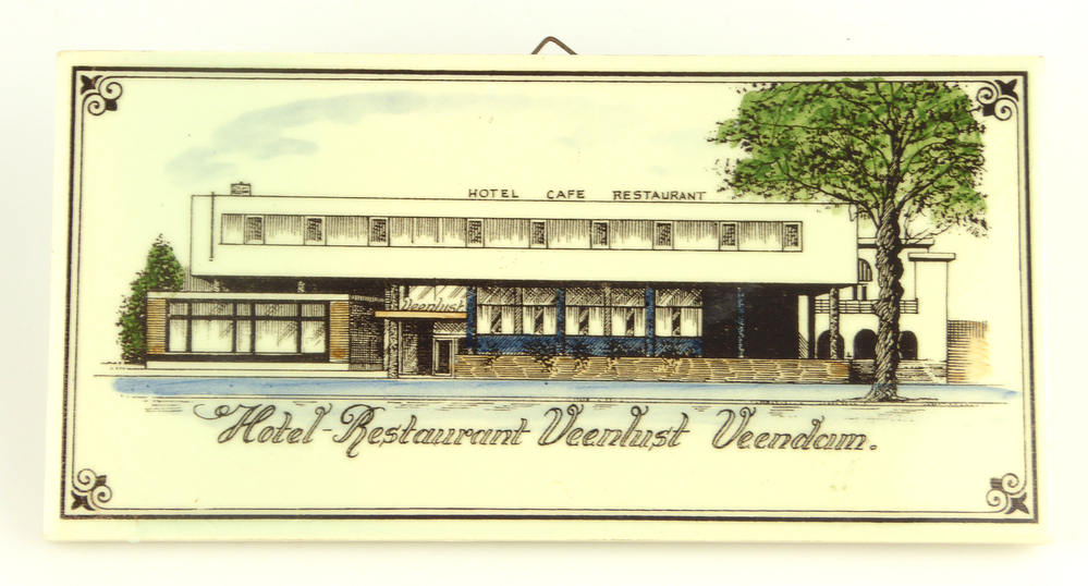 langwerpige tegel met handgeschilderde polychrome afbeelding Veenlust Veendam in de kleuren zwart bruin blauw groen en wit met daaromheen sierrand en onder zwarte belettering Hotel restaurant Veenlust Veendam, gemaakt door Koninklijke Sphinx te Hemiksem. (Sphinx nam deze aardewerkfabriek in  Belgie in 1968 over en produceerde daar tot 1977)