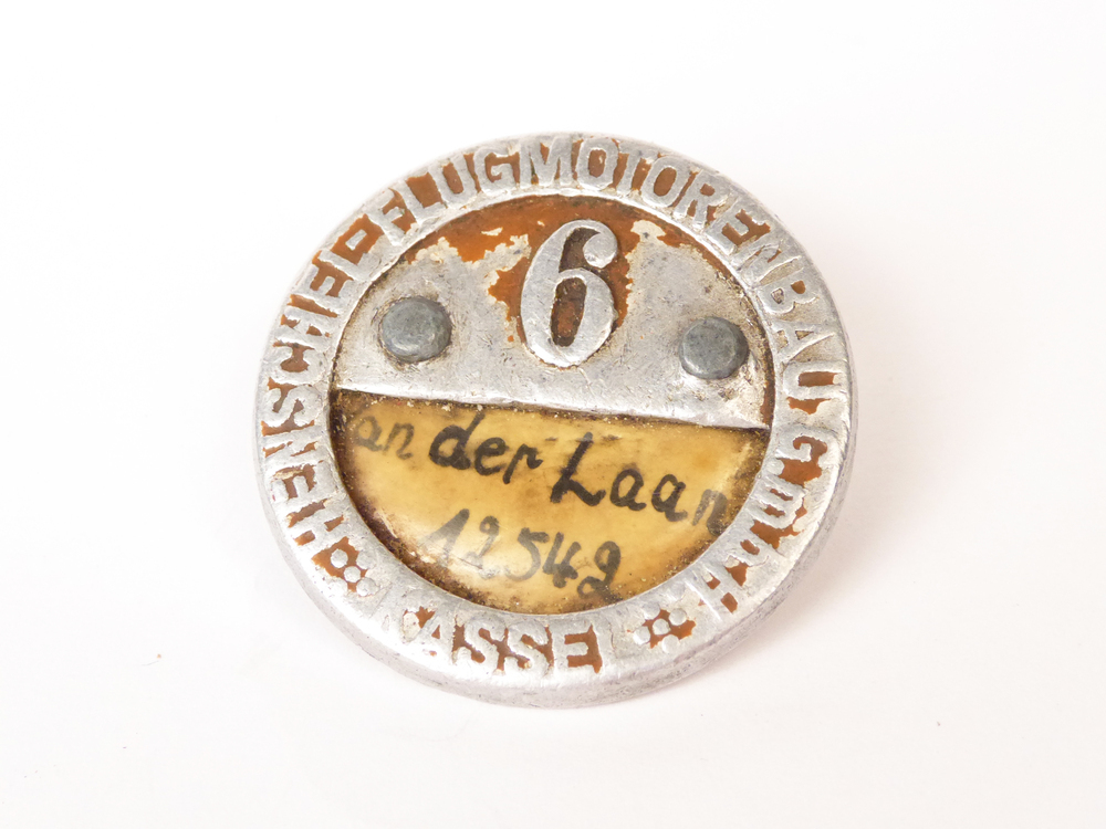 gegoten aluminium plaatje van Filippus van der Laan, geboren 28-5-1923 te Wildervank, overleden 5-11-2004 uit de tijd dat hij tewerkgesteld was bij Henschel Flugzeugbau GMBH te Kassel. Hij had registratienummer 6. Plaatje is an de onderkant halfopen en op het papiertje binnenin staat vermeld Van der Laan 12542, zijn achternaam en datum dat hij daar aankwam.