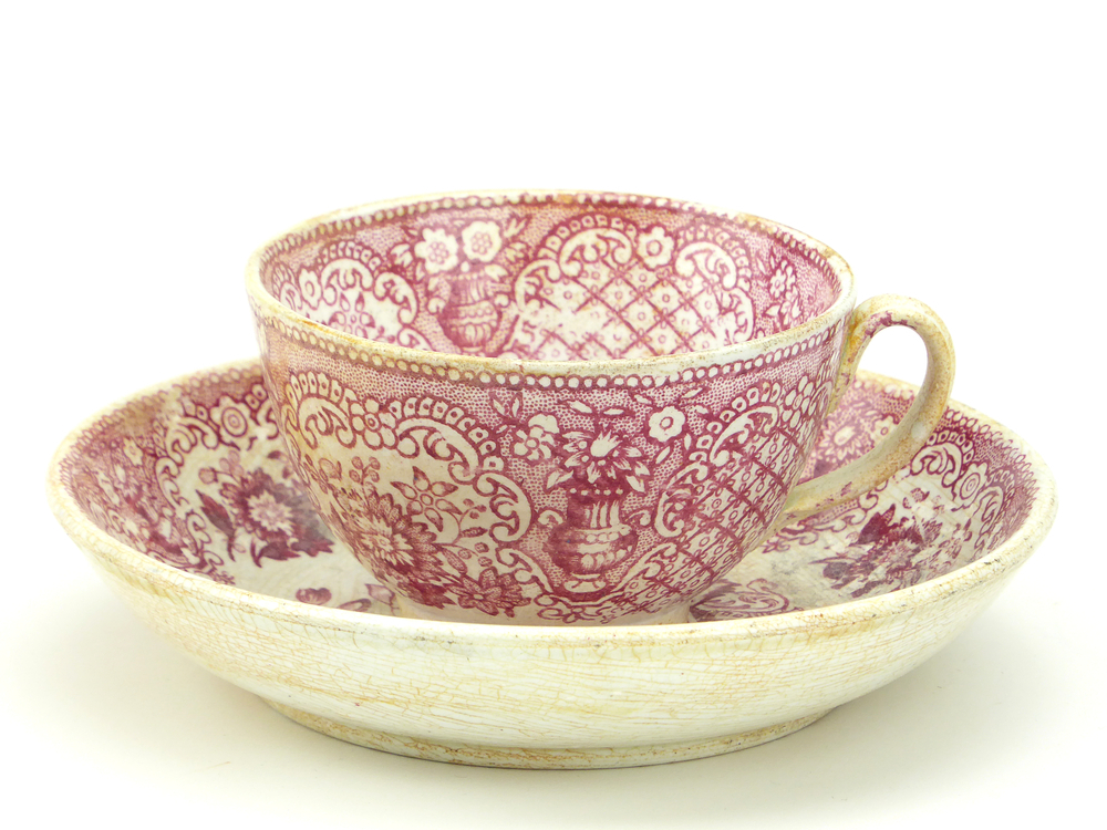 aardewerken kop en schotel van het merk Petrus Regout & Co, Maastricht, kop diameter 8 cm, schotel diameter 13,5 cm, op buiten en binnenkant rode decoratie van bloemen en bloemenvaas, blindmerk 4, gemerkt met beeldmerk 71 A van Petrus Regout, schotel decornaam Banka, opgedoken door British Sub Aqua Club, Branch 501, ook wel de 501 Divers uit Folkstone, uit het wrak van de op 19 november 1887 na een aanvaring met het stoomschip Rosa Mary gezonken stoomschip W.A. Scholten, via hun woordvoerder Glyn Jones geschonken aan het Veenkoloniaal Museum.