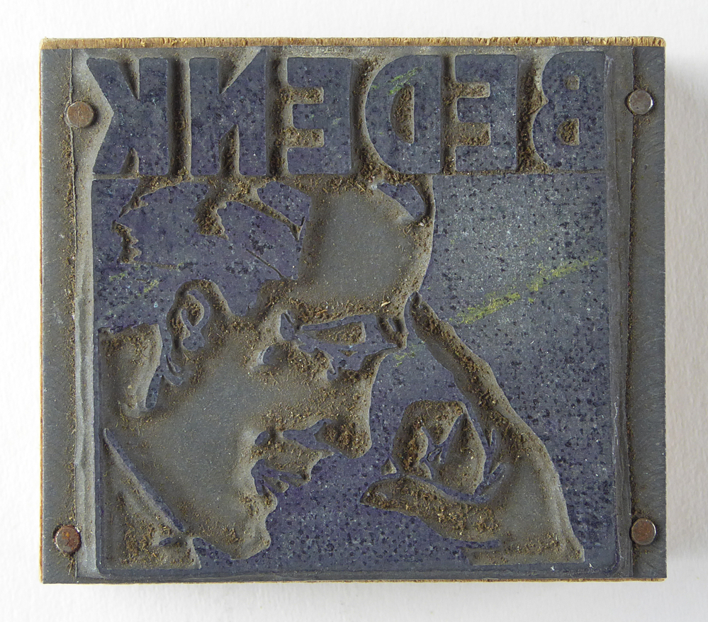 kleine houten cliche met non ferro metalen matrijs met inscriptie bedenk, afkomstig van kantoorinstallatie BV Schuur te Veendam