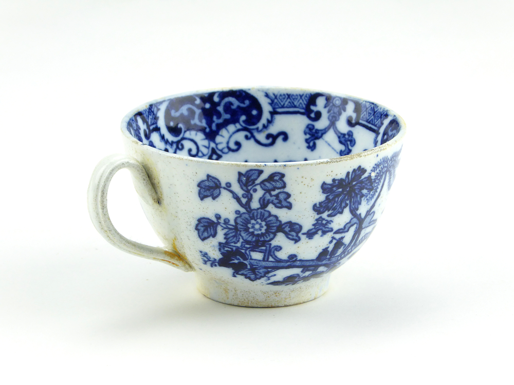 aardewerken kop van het merk Petrus Regout & Co, Maastricht, diameter 8,2 cm, blauw decoratie van bloemen, bomen, een man op een loopbrug loopt langs een zittende man, op de achtergrond een pagode, kop gemerkt met beeldmerk 71 A van Petrus Regout, opgedoken door British Sub Aqua Club, Branch 501, ook wel de 501 Divers uit Folkstone, uit het wrak van de op 19 november 1887 na een aanvaring met het stoomschip Rosa Mary gezonken stoomschip W.A. Scholten, via hun woordvoerder Glyn Jones geschonken aan het Veenkoloniaal Museum.