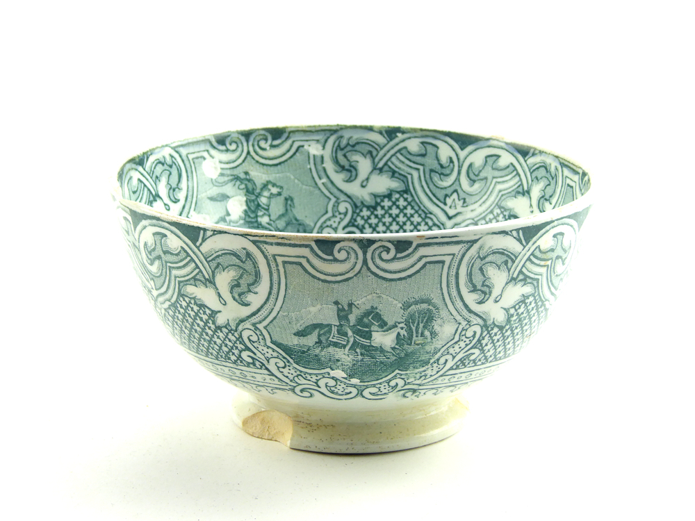 aardewerken kom op standvoet van het merk Petrus Regout & Co, Maastricht, decornaam Lasso, diameter 14,9 cm, op binnenkant 4 x groene decoratie van man op paard met lasso die paarden vangt, buitenkant groene decoratie van loslopende paarden en man op paard met lasso, chip uit standvoet en bovenrand, gemerkt met beeldmerk 71 A van Petrus Regout, opgedoken door British Sub Aqua Club, Branch 501, ook wel de 501 Divers uit Folkstone, uit het wrak van de op 19 november 1887 na een aanvaring met het stoomschip Rosa Mary gezonken stoomschip W.A. Scholten, via hun woordvoerder Glyn Jones geschonken aan het Veenkoloniaal Museum.