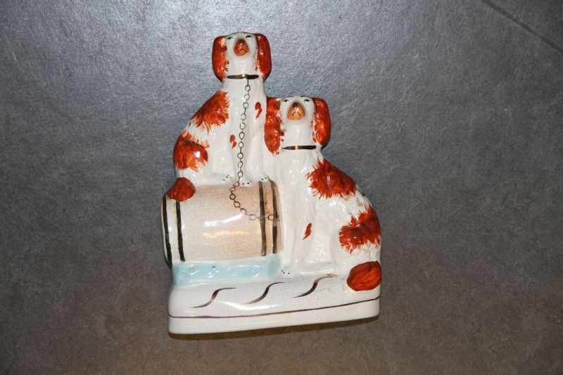 steengoed beeld van 2 honden, King Charles Spaniels, waarvan de linker gezeten op een bruinige vat met 4 duigen, ketting van hond loopt naar beneden naar het vat, op een lichtblauwe ondergrond, op onderkant gemerkt V, 15 x 6 x 21,5 cm, Staffordshire, 1860