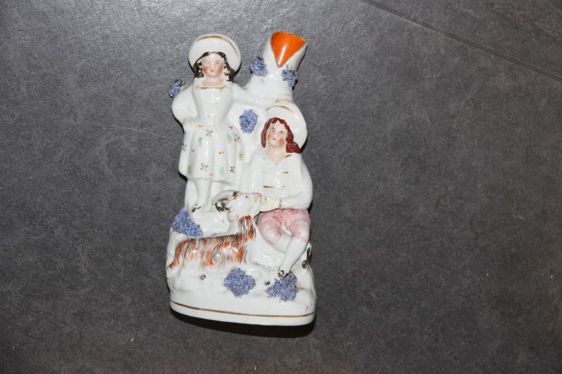 aardewerken beeldengroep van meisje en een jongen naast een boom, voor hen een geit