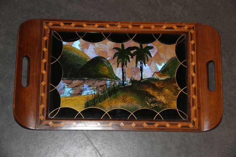 dienblad met collage van vlindervleugels, voorstellende een baai te Rio de janeiro met huis op heuvel, inscriptie Santos Brasil, omgeven door houten inlegwerk