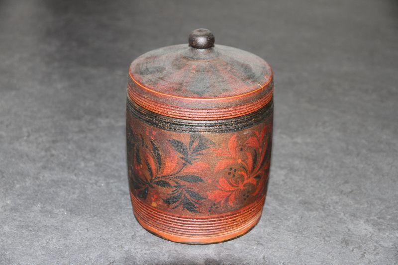 tabakspot van berkenhout met op buitenkant rood zwarte floraal motief, deksel met knop, binnenkant deksel zilverkleurig