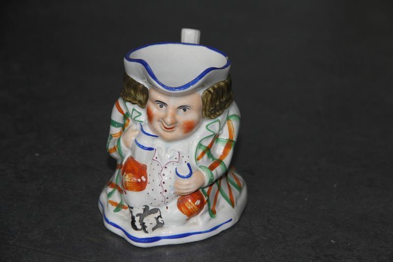 aardewerken kannetje in de vorm van een mannetje met handgreep